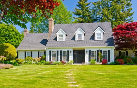 Custom built luxury house with nicely trimmed and landscaped front yard, lawn in a residential neighborhood. Vancouver Canada.
